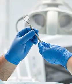 Dental assistant handing tool to dentist